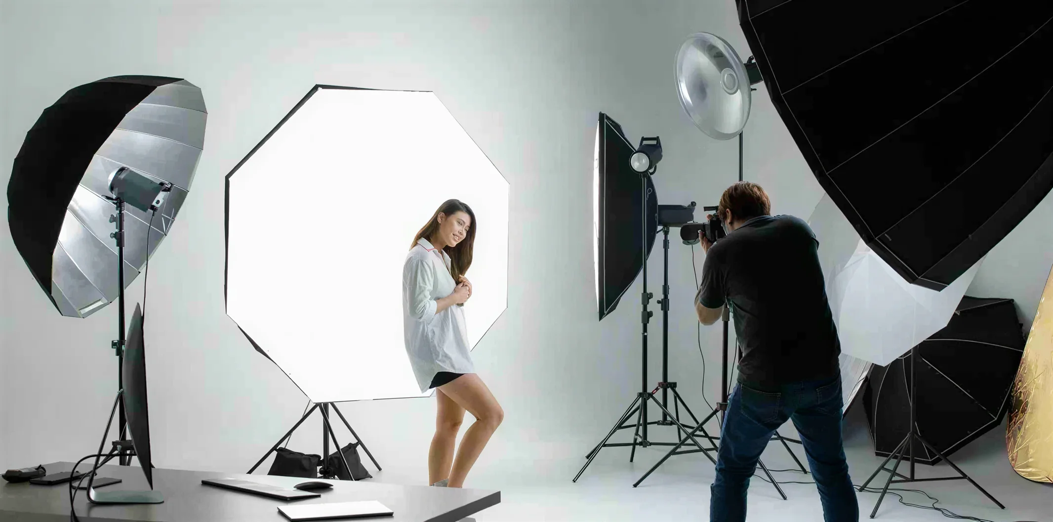 A traditional studio fashion shoot with lights, a photographer and a model