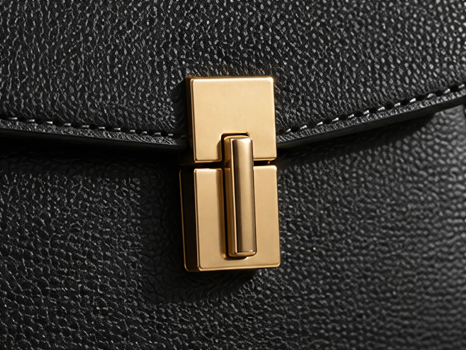 Close-up of the gold clasp and pebbled leather on the handbag