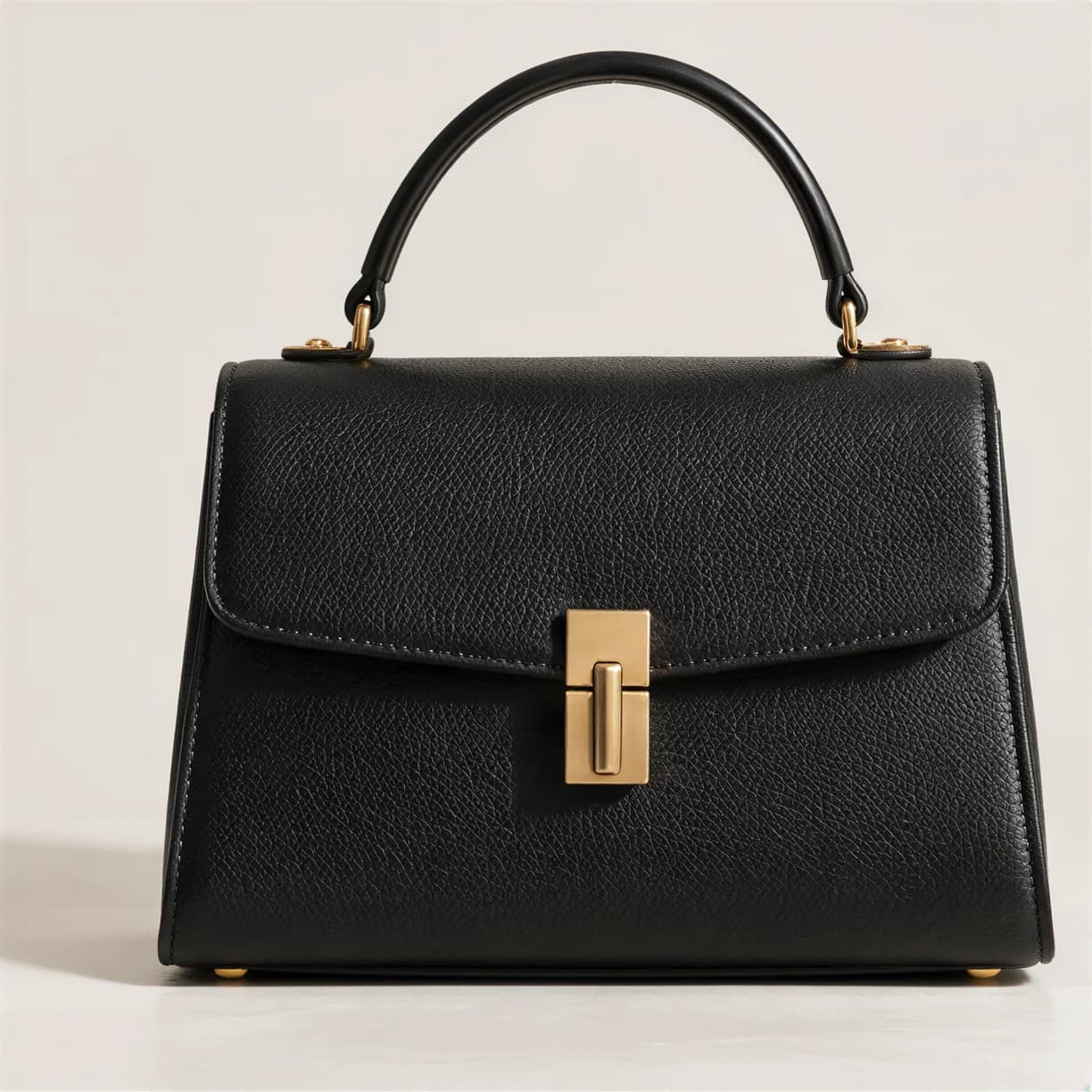 Structured black leather handbag with a gold clasp