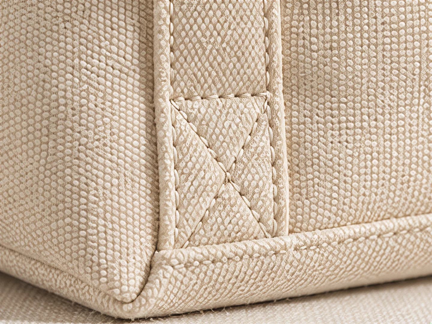Close-up of the stitched base corner and handle seam of the tote