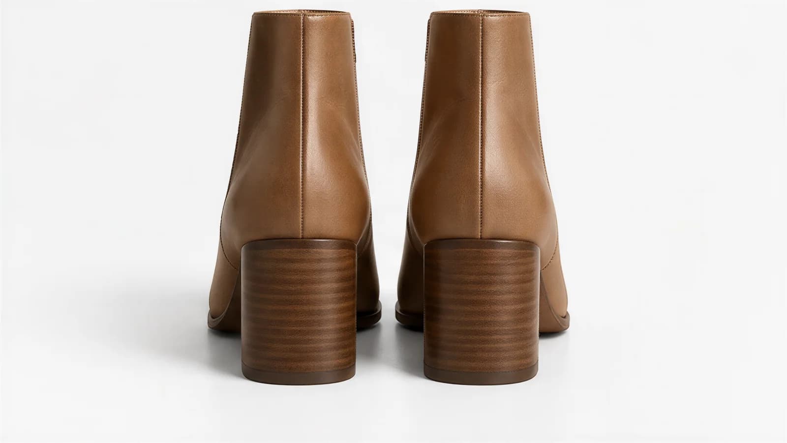 The pair of tan ankle boots seen from behind, showing the stacked wooden block heels