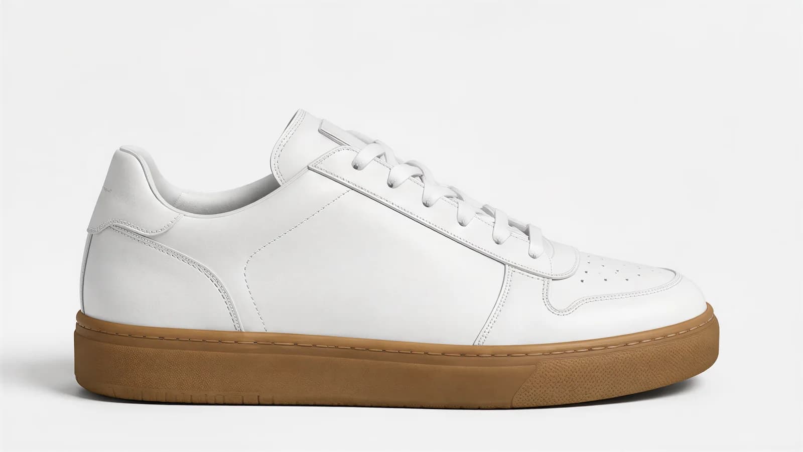 One white leather sneaker with a gum sole in a studio side profile on a white background